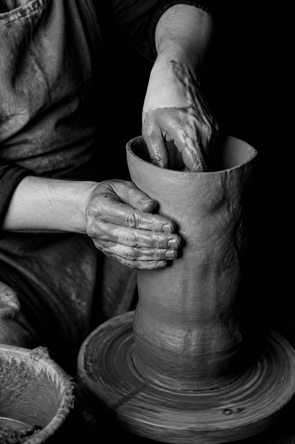 Hands shaping rough local clay